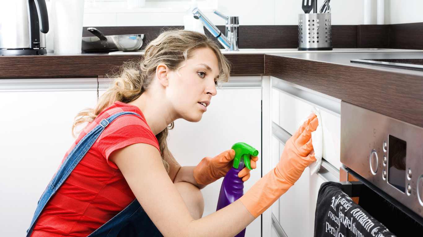 woman cleaning greasy cabinets