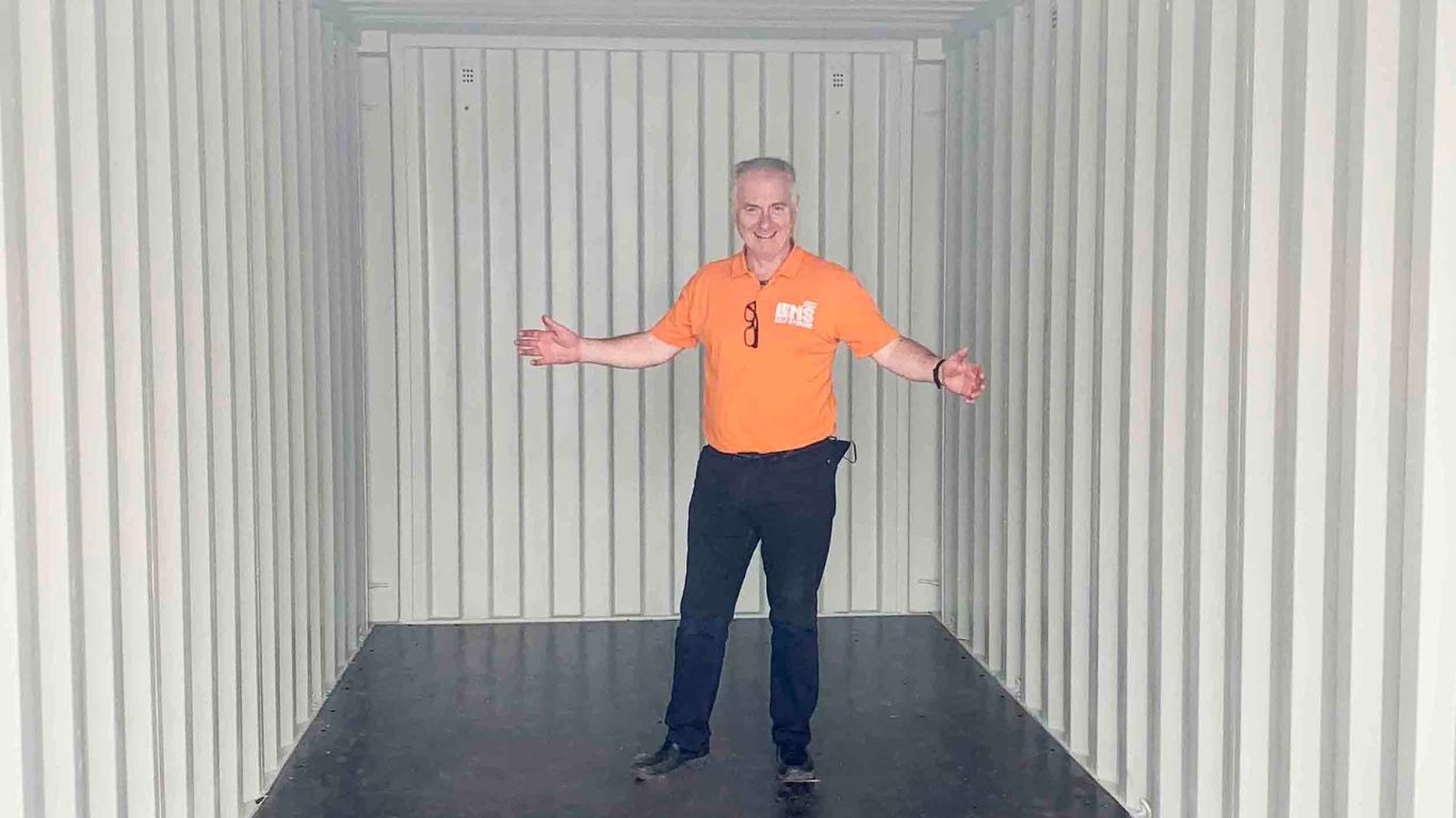 A man standing in an empty storage unit 