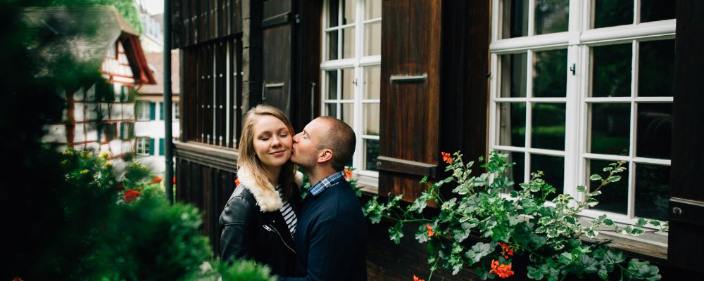 A smiling couple in front of their house