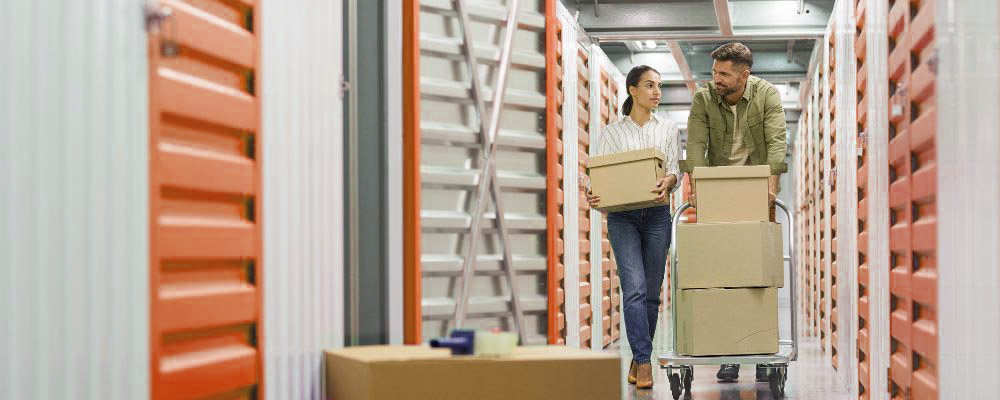 A couple packing boxes in a self storage unit