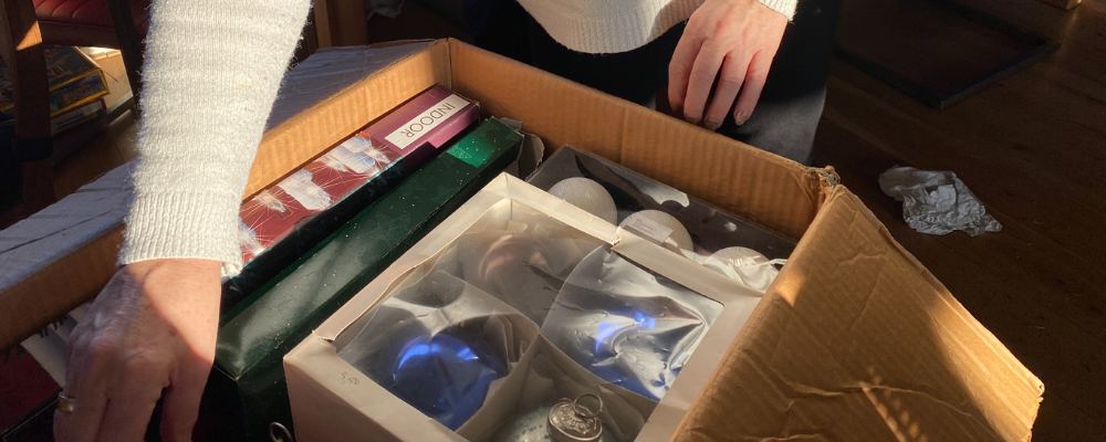 A person packaging their Christmas decorations away