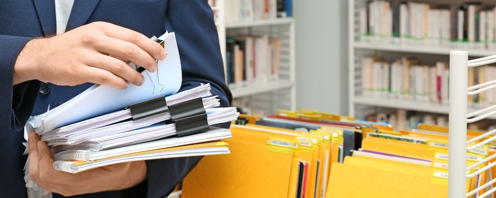 Someone putting documents into a storage box