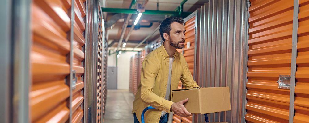 Man storing his box of documents in at a storage facility