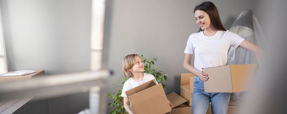 A mom with her kids busy packing items away into cardboard boxes