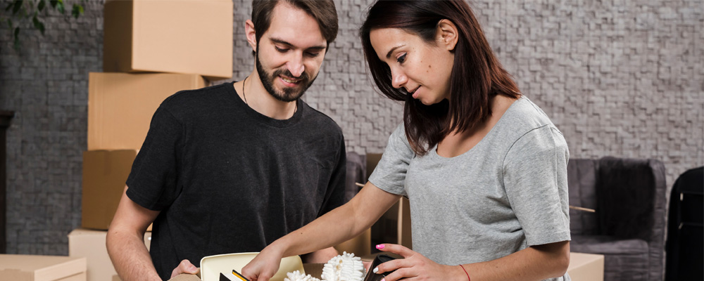 Parents helping their student child pack up items into a moving box